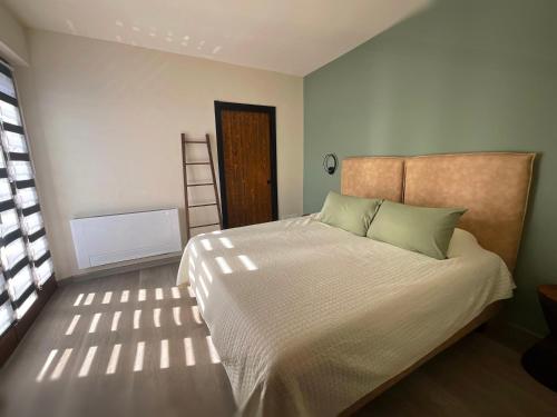 een slaapkamer met een groot wit bed met groene kussens bij Agriturismo Casafaro Petritoli in Petritoli