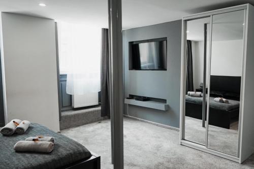 - une chambre avec un miroir, un lit et une télévision dans l'établissement Downtown studios Budapest, à Budapest