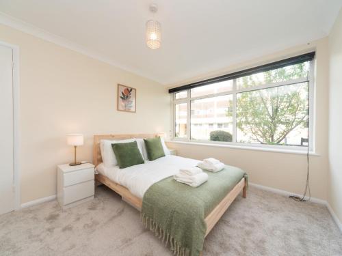 a bedroom with a bed and a large window at Pass the Keys Great apt 20 mins central London in Surbiton