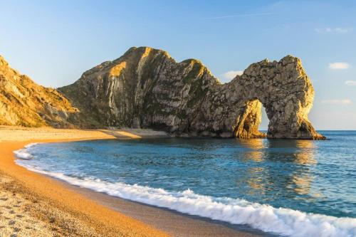 a view of a beach with an arch in the water at Close to Jurassic Coast 3 Bed modern house in Wool