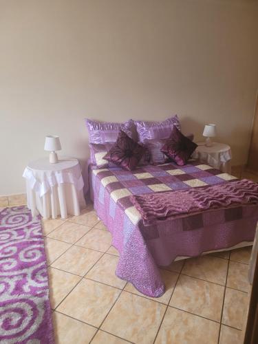 1 dormitorio con 1 cama de color púrpura y 2 mesas en Annie Studio, en Heidelberg