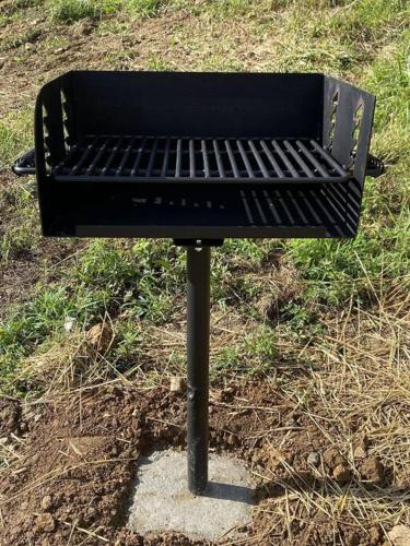 a black bench sitting on the ground in the grass at Campfire Memories in Sevierville