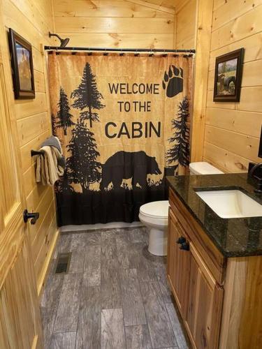 a bathroom with a shower with a welcome to the cabin at Campfire Memories in Sevierville