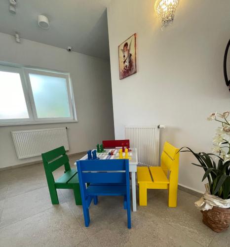 a room with colorful chairs and a table at Zafír in Dunajská Streda