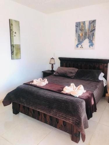 a bedroom with a bed with two towels on it at Hotel Casa Cantabria Campestre in Villa de Leyva