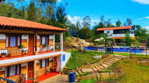 a resort with a swimming pool and a house at Hotel Casa Cantabria Campestre in Villa de Leyva