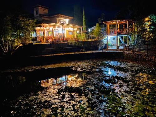a lit up building next to a pond at night at Hotel Casa Cantabria Campestre in Villa de Leyva
