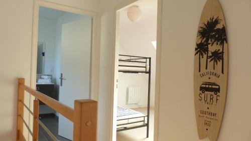 une planche de surf est suspendue sur un mur à côté d'une porte dans l'établissement Maison tout confort en bord de mer à Quiberon, à Quiberon