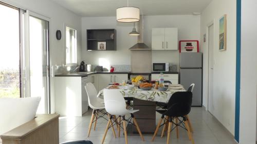 une cuisine avec une table et des chaises dans une cuisine dans l'établissement Maison tout confort en bord de mer à Quiberon, à Quiberon