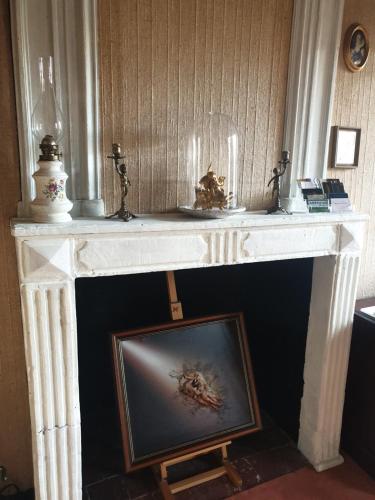 a white console table with a picture under it at LA GAUDINIERE in Lyons-la-Forêt