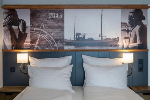 蒂門多爾費爾斯特蘭德的住宿－4Hafenzeiten - Ferienwohnung NIE 3 Möve，一间卧室配有带两个枕头和一条船的床。