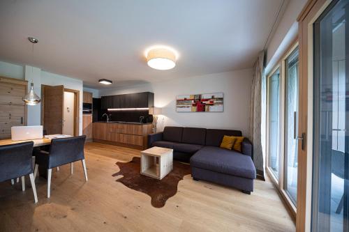 a living room with a couch and a dining room at Lakeside Luxury Apartments in Zell am See