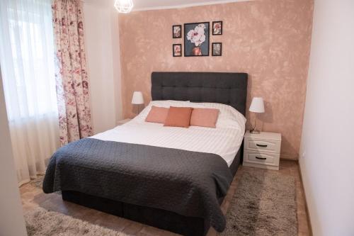 a bedroom with a large bed with a black headboard at Urban Oasis in Piatra Neamţ