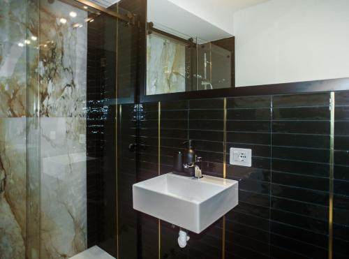 ein Bad mit einem Waschbecken und einer Dusche mit einem Spiegel in der Unterkunft FiDa Rooms in Neapel