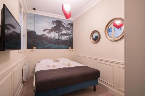 une chambre avec un lit et un miroir au mur dans l'établissement Modern and Cosy flat in the heart of Notre Dame, à Paris