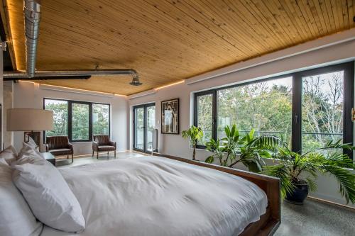 a bedroom with a large bed and large windows at Penthouse - Spa-Inspired Guest Suite, Halifax Rooftop Home in Halifax