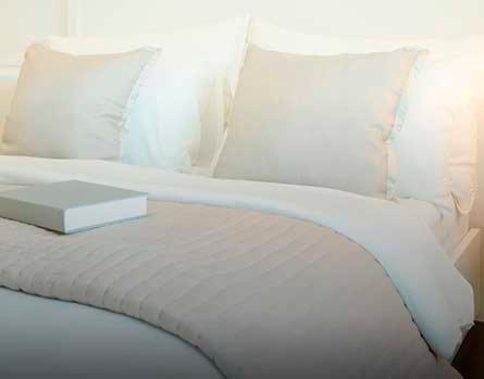 Una cama blanca con un libro encima. en Citrea Santander, en Santander