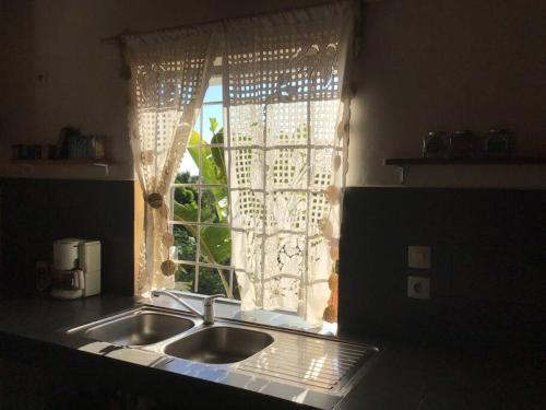 eine Küchenspüle vor einem Fenster in der Unterkunft Villa Kanto - Belle maison et jolie vue Mga centre in Mahajanga