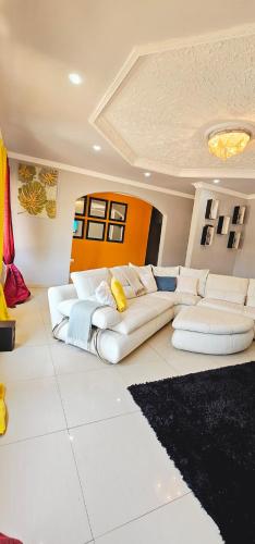 una sala de estar con un sofá blanco en una habitación en EMC Luxury 4BR Villa ,Pool, Solar , Starlink Wifi, en Lusaka