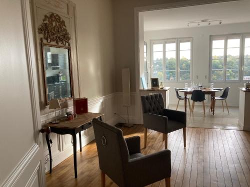 a living room with a table and chairs and a dining room at Golf & Rempart in Angoulême