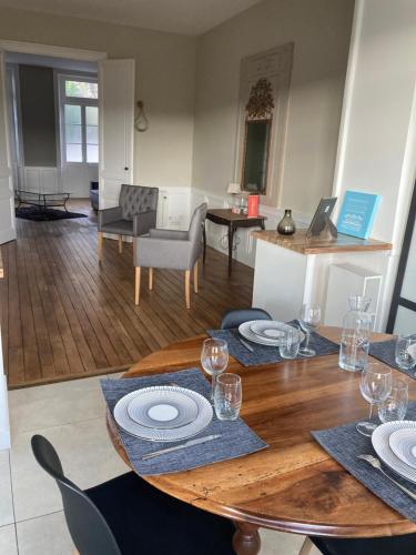 a dining room with a table with plates and wine glasses at Golf & Rempart in Angoulême