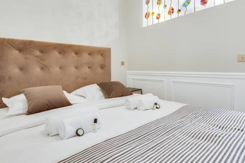 een groot wit bed met 2 handdoeken erop bij Lovely flat in Central Paris near Notre-Dame in Parijs