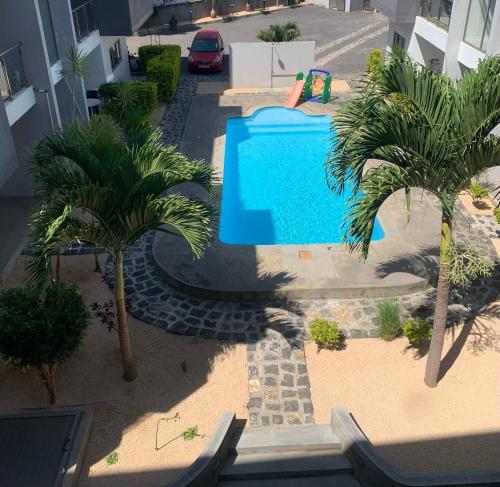 una vista aérea de una piscina con palmeras en Ibiza Apartment - 150m from the beach, en Flic en Flac