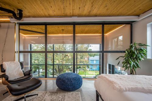 a bedroom with a bed and a chair and a large window at Sunrise View - Spa-Inspired Guestroom, Halifax Rooftop Home in Halifax