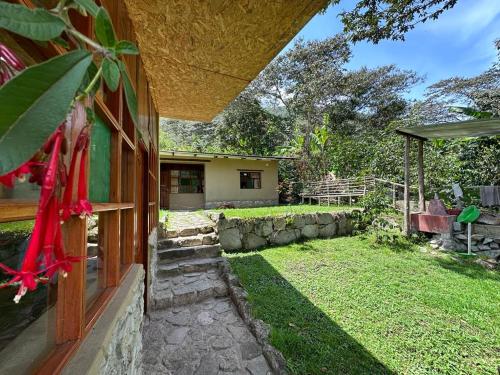 a house with a yard with a stone wall at Lia B&B Lucmabamba in Sahuayacu