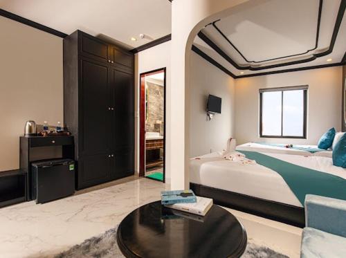 een slaapkamer met een bed, een bank en een tafel bij Simon House Hoi An in Hội An