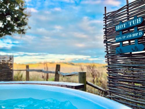 a hot tub with a sign next to a fence at The Green Hut in Battle