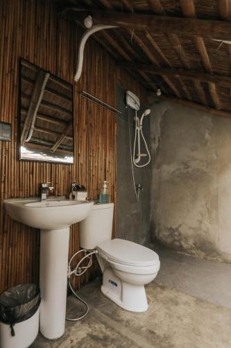 a bathroom with a toilet and a sink at Marika Resort in Badian