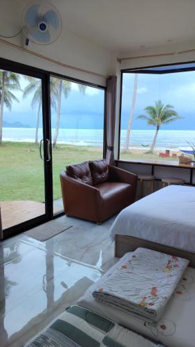 a bedroom with a bed and a view of the beach at Baan Be Beach in Lang Suan