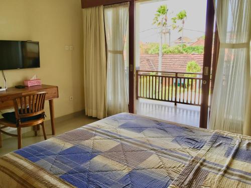 - une chambre avec un lit, un bureau et une fenêtre dans l'établissement Villa Jalak Kembar, à Canggu
