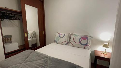 um pequeno quarto com uma cama e um espelho em Flat Funchal JK Vila Olímpia Limpeza Diária em São Paulo