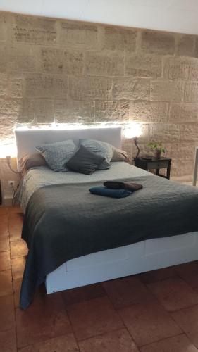 バルサックにあるStudio et jardin au cœur des vignes - 1 à 4 pers -のレンガの壁のベッドルーム1室(大型ベッド1台付)