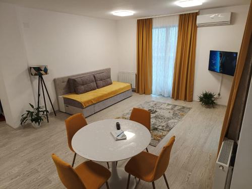 uma sala de estar com uma mesa e cadeiras e um sofá em Apartament Genius 2 em Ploiesti