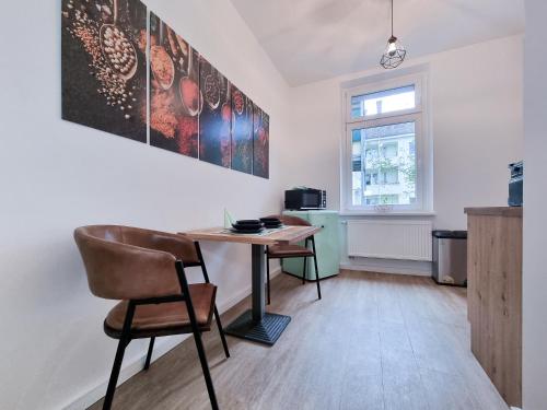 a dining room with a table and chairs and a window at Alpha Apartments in Dortmund