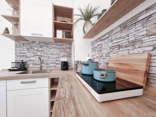 a kitchen with a sink and a brick wall at Alpha Apartments in Dortmund