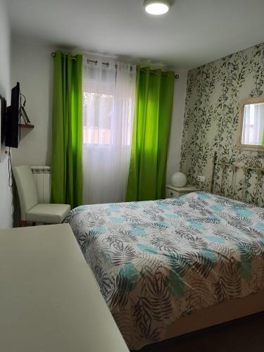a bedroom with green curtains and a bed and a window at Apartamento Piles Playa in Piles
