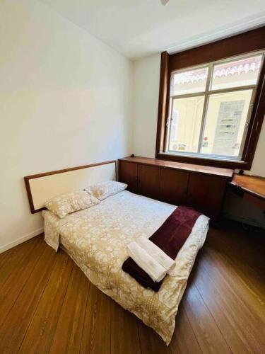 a bedroom with a bed and a window at Apartamento no Leblon in Rio de Janeiro