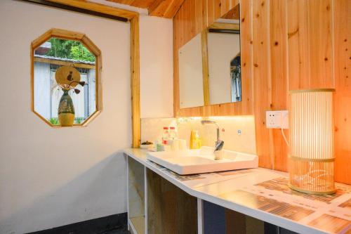 a bathroom with a sink and a mirror at 云起山居庭院观景民宿 in Fenghuang