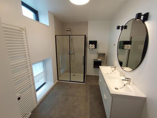 uma casa de banho com um chuveiro, um lavatório e um espelho. em L'Escale Buissonnière - Cosy and quiet house em Rochefort