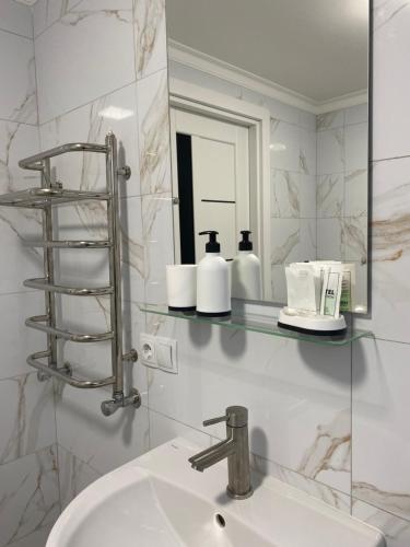 y baño con lavabo y espejo. en Gallery Elit Hotel, en Dunaivtsi
