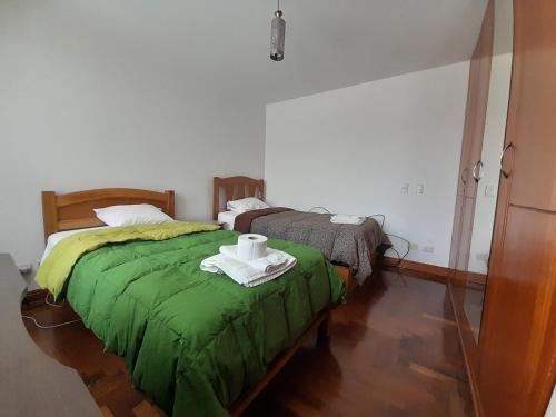 1 dormitorio con 2 camas y edredón verde en departamento elegante y amplio, en Arequipa