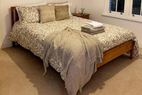 een slaapkamer met een bed met een deken en een raam bij Spacious 2-Bed Apartment in Oxford in Oxford