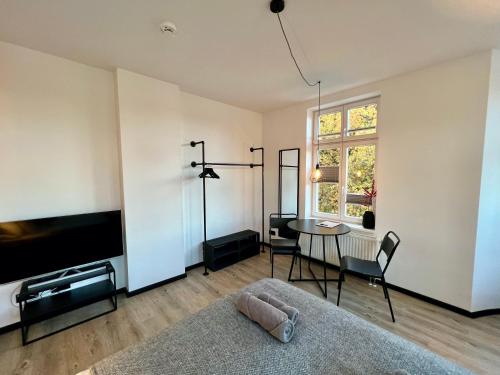 a living room with a tv and a table at Apartmenthaus Buxtehude St -Petri-Platz Apt 4 in Buxtehude