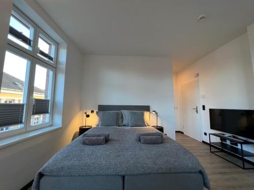 a bedroom with a large bed and a flat screen tv at Apartmenthaus Buxtehude St -Petri-Platz Apt 4 in Buxtehude