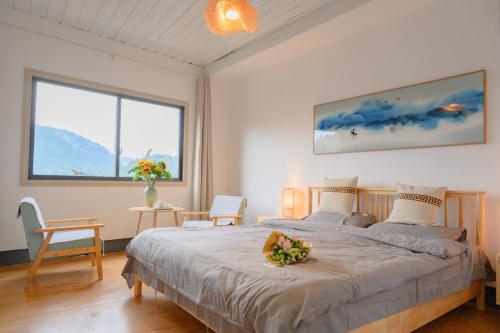 鳳凰的住宿－云起山居庭院观景民宿，一间卧室配有一张带鲜花的大床