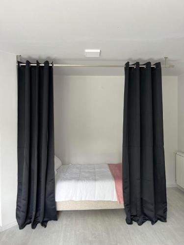 1 cama con cortinas negras en un dormitorio en Apartment Aria, en Skopje